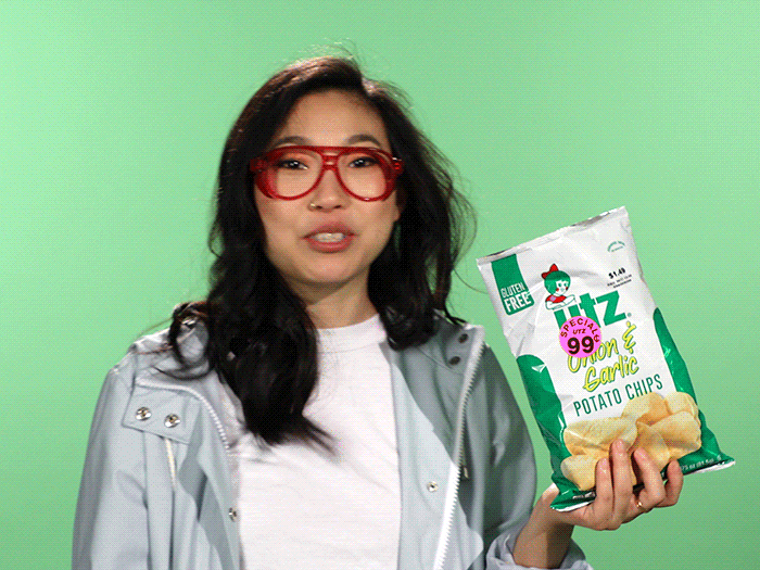 a gif of a woman eating potato chips and dancing
