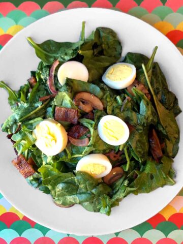 a plate of Keto Spinach Salad with Warm Bacon Dressing