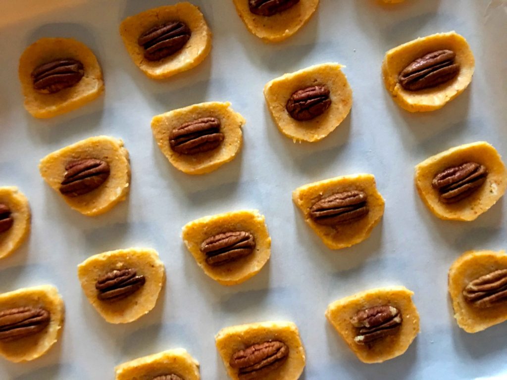 uncooked cheese pecan crackers on a baking sheet