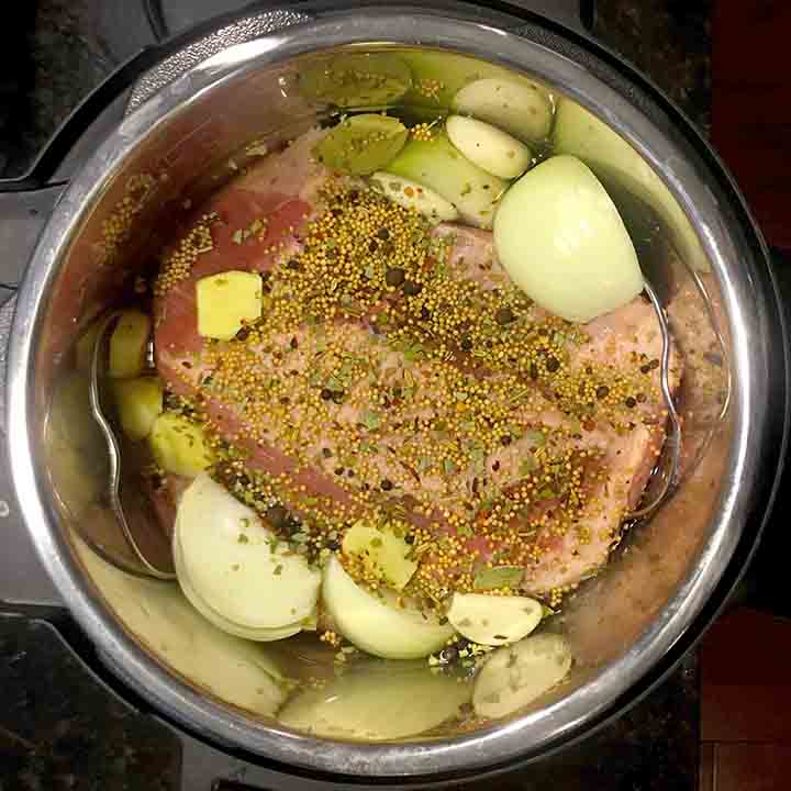 A top down view of an Instant Pot holding a Keto corned beef and onions and seasonings