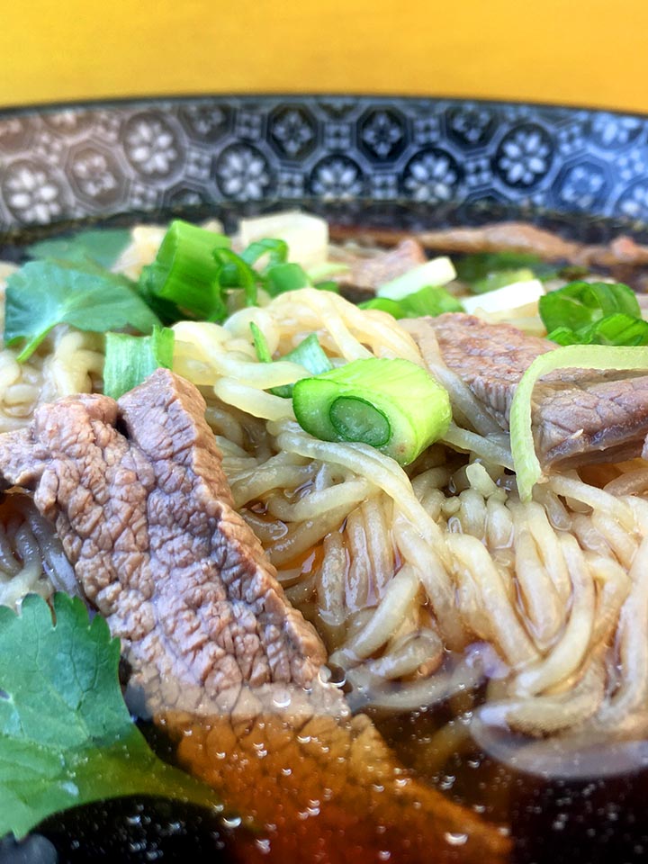 a close up image of a bowl of low carb beef pho