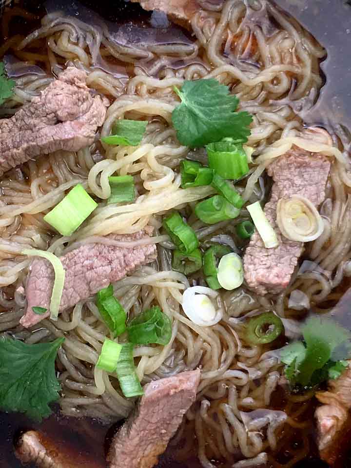 a close up of a bowl of Keto pho noodles and strips of steak