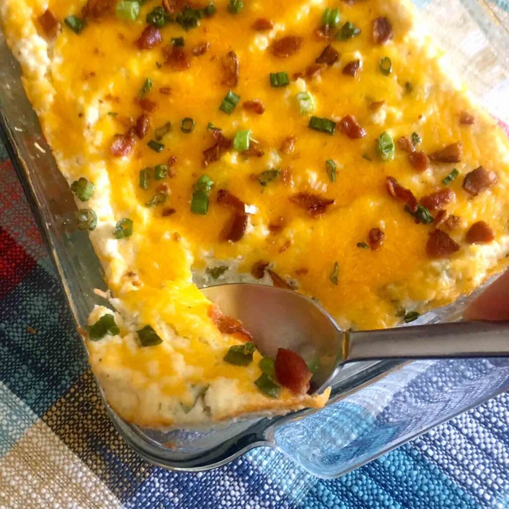 Top down view of Keto Twice Baked Cauliflower with melted cheese, bacon and green onions