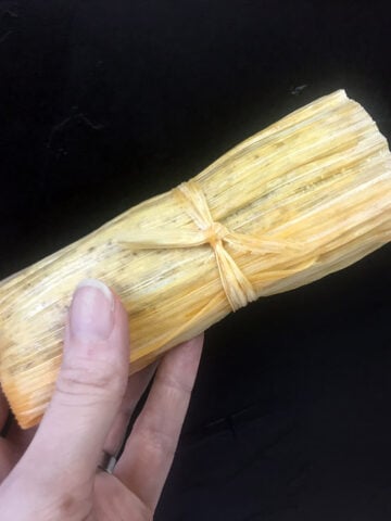 a hand holds a Keto Beef Tamale