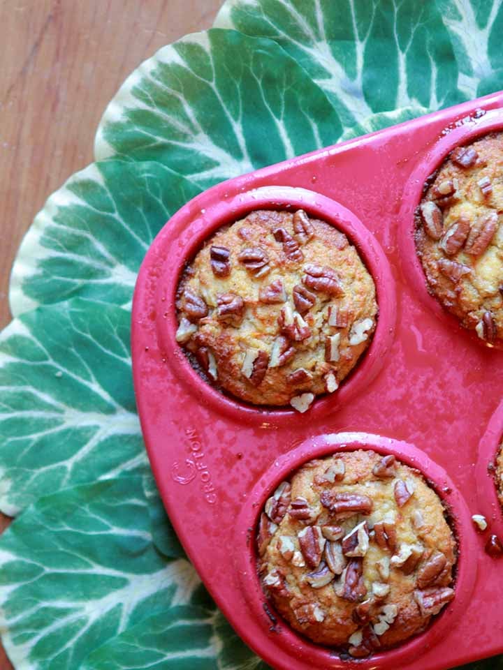 a top down view of a pink muffin pan holding low carb cream cheese filled carrot muffins
