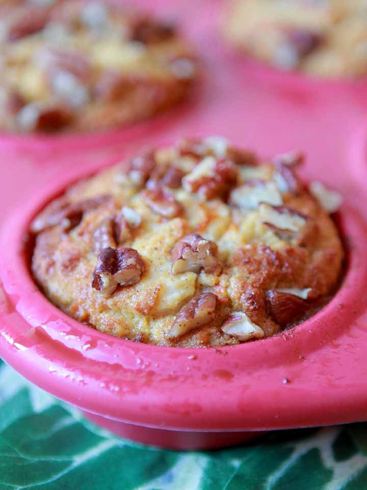 a close up view of a pink muffin pan holding a Keto Carrot Cake Muffin