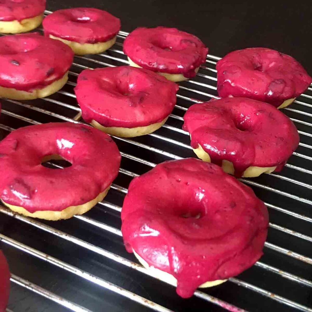 a rack of Keto Lemon Donuts with Blueberry Frosting
