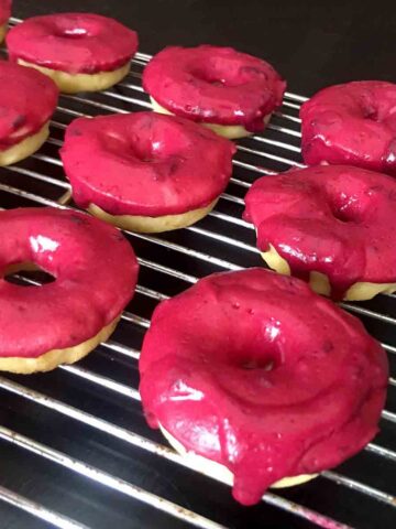 a rack of Keto Lemon Donuts with Blueberry Frosting