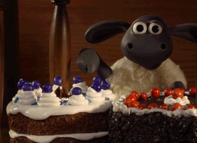 a gif of a sheep pointing to a gluten free cream filled chocolate cake