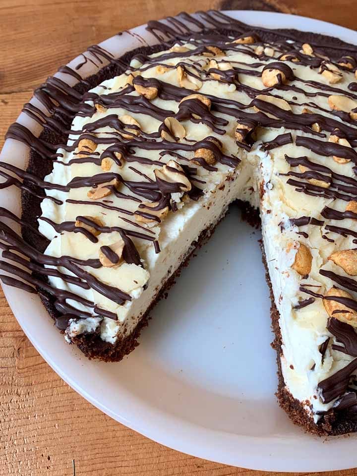 a side view of a Snickers Pie with a slice cut out of it