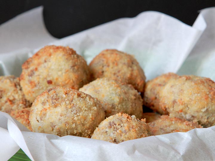 A basket filled with low carb sauerkraut balls against a black background