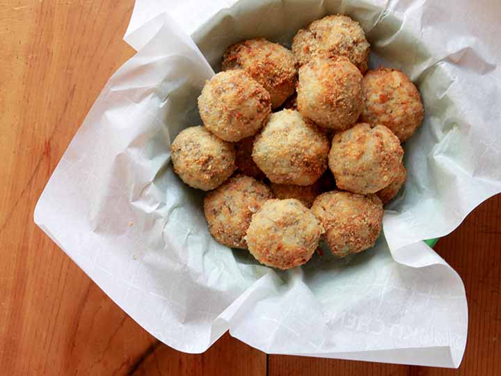 A basket filled with low carb sauerkraut balls against wooden tabletop