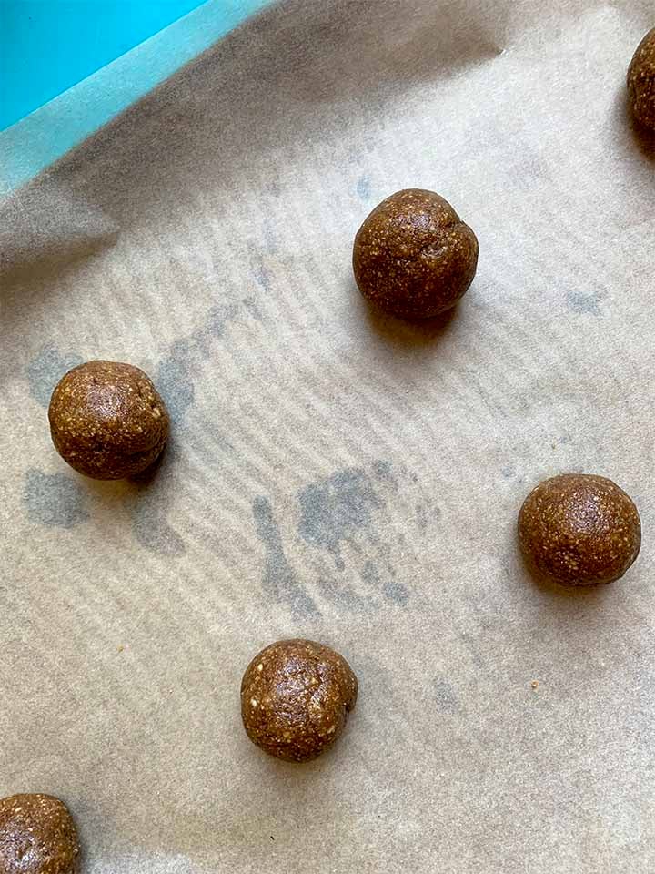 cookie dough balls on a parchment covered baking sheet