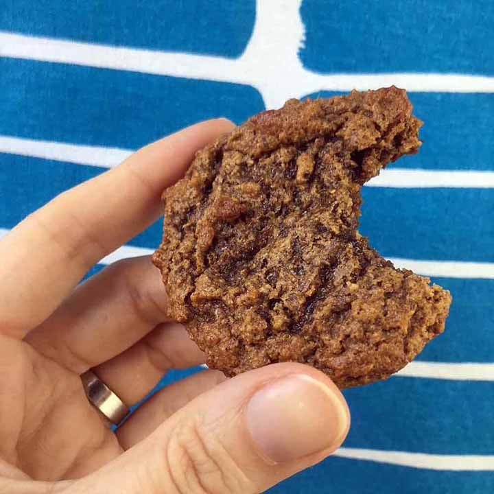 a hand holds a Keto Molasses Gingerbread Cookie