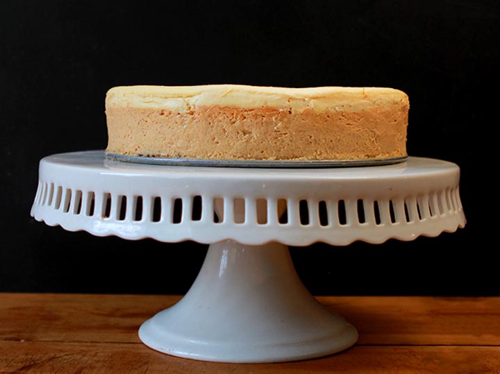 A sugar-free Keto pumpkin cheesecake on a white pedestal