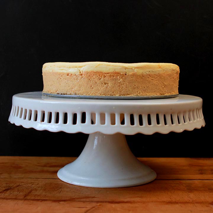 A sugar-free Keto pumpkin cheesecake on a white pedestal