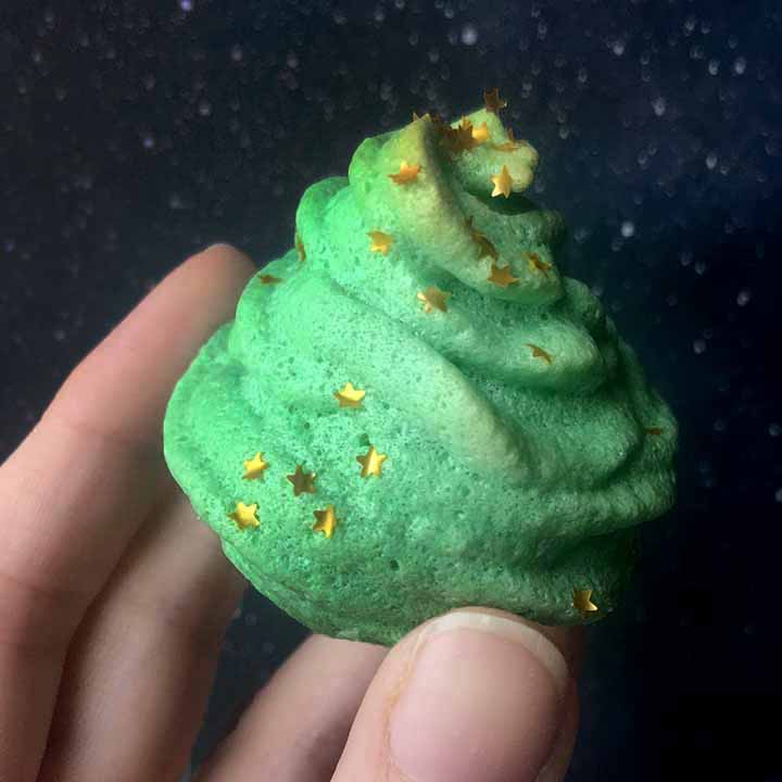 a hand holds a Keto christmas tree meringue cookie