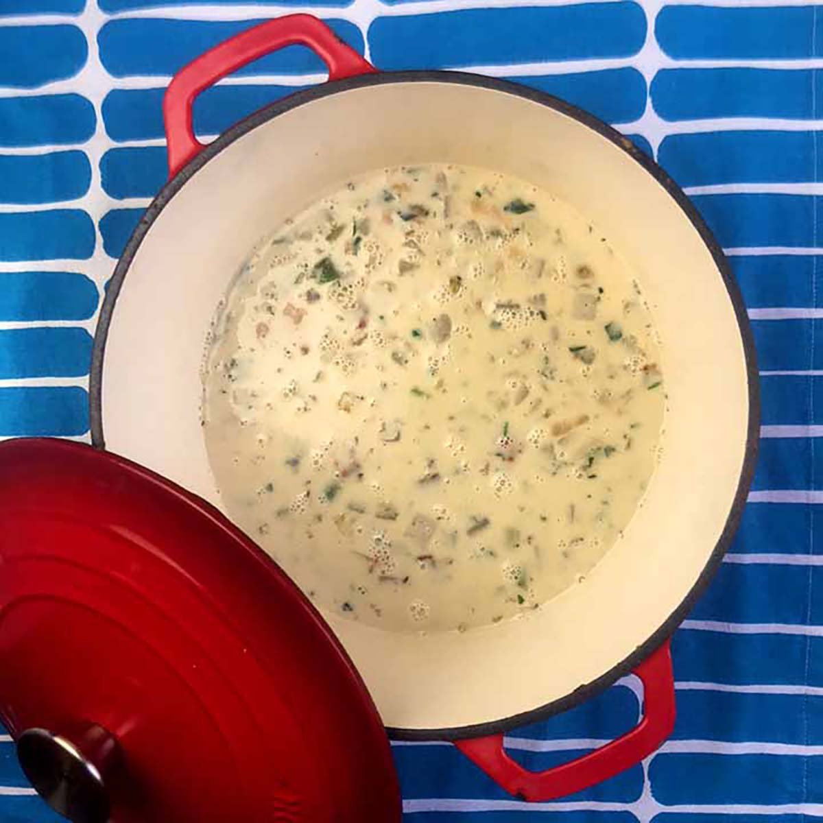a pot of Keto Clam Chowder against a blue patterned background
