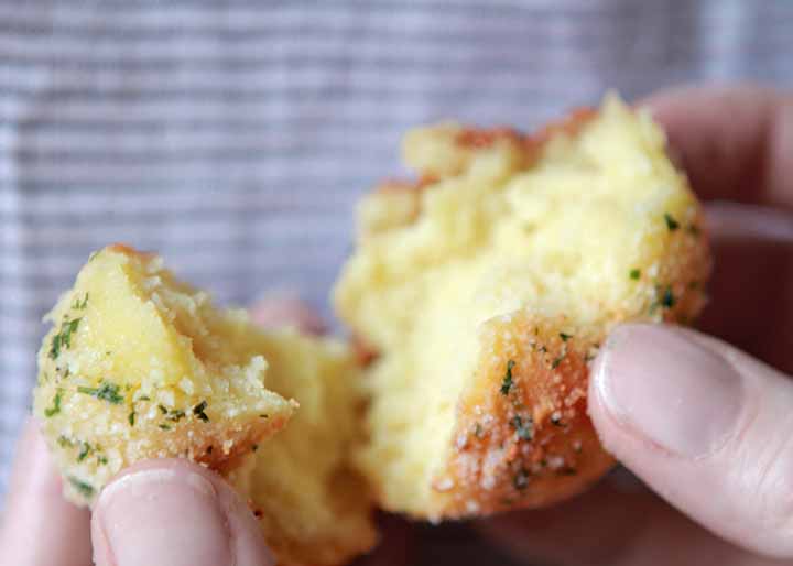 hands hold a piece of Low carb Garlic bread