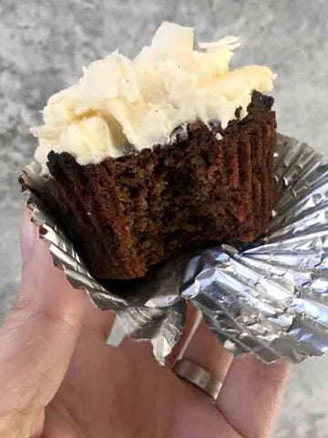 a hand holds a Keto Chocolate Coconut Cupcake