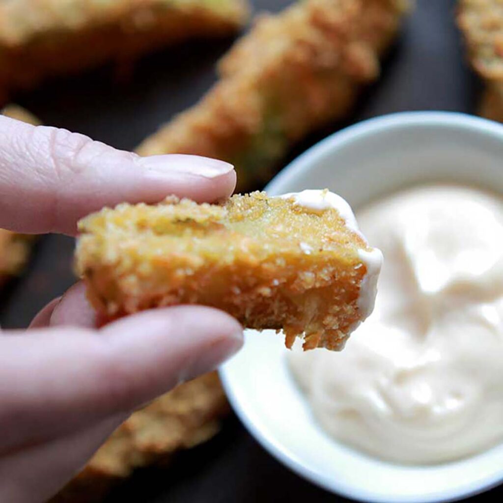 a hand holds a Keto Fried Pickle