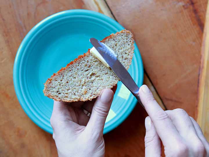 hands butter a slice of Keto rye bread