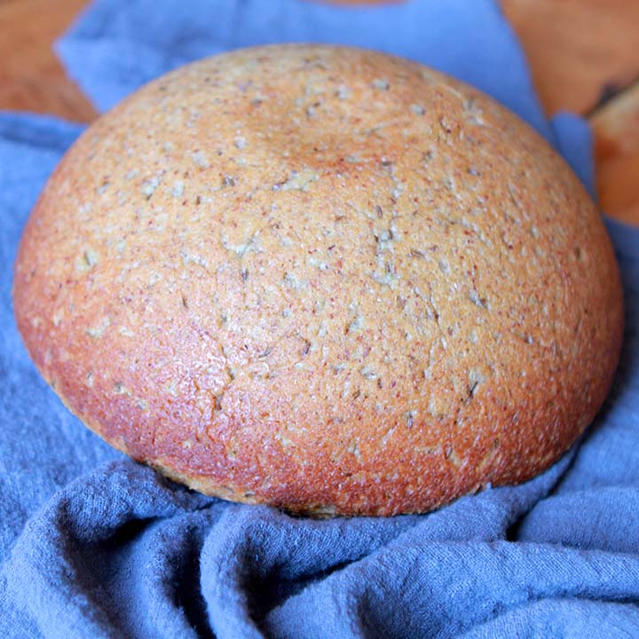 a loaf of Paleo rye bread against a navy blue napkin