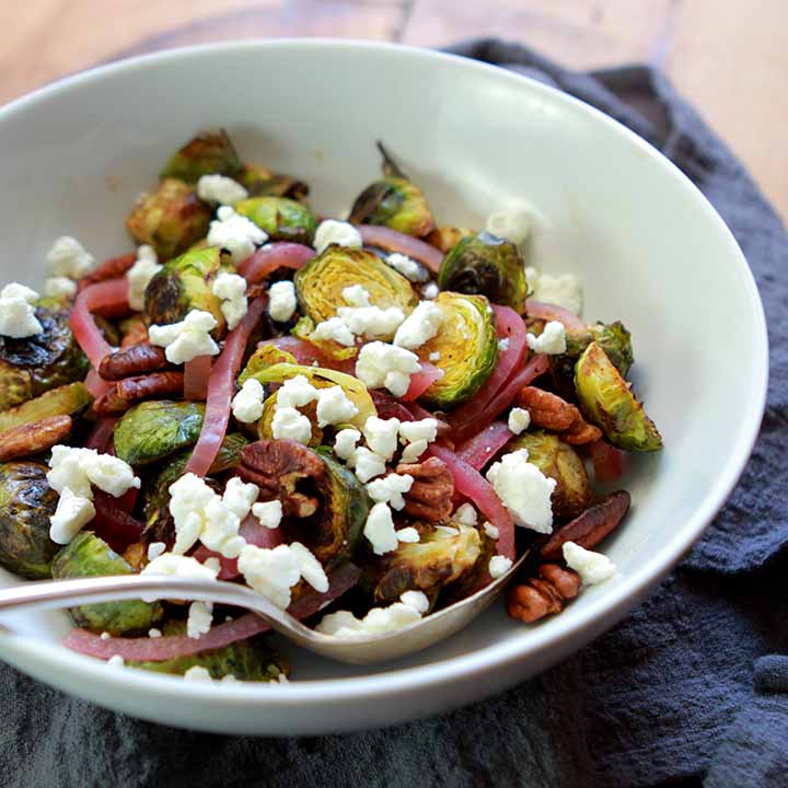 A bowl of Keto Charred Brussel Sprouts with Pecans, Feta Cheese and Quick Pickled Red Onions