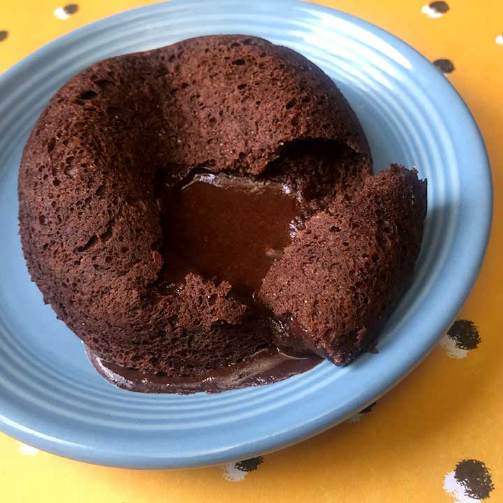 A low carb lava cake on a blue plate against a yellow patterned background