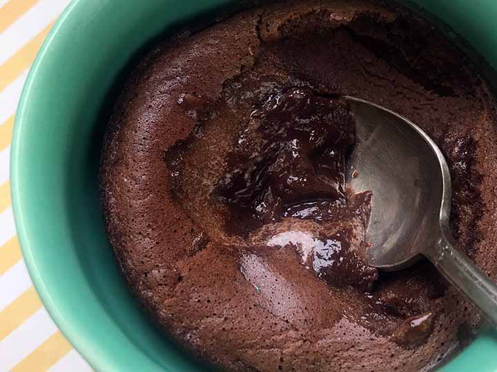 Close up shot of a Keto Lava Cake in a blue mug with a spoon