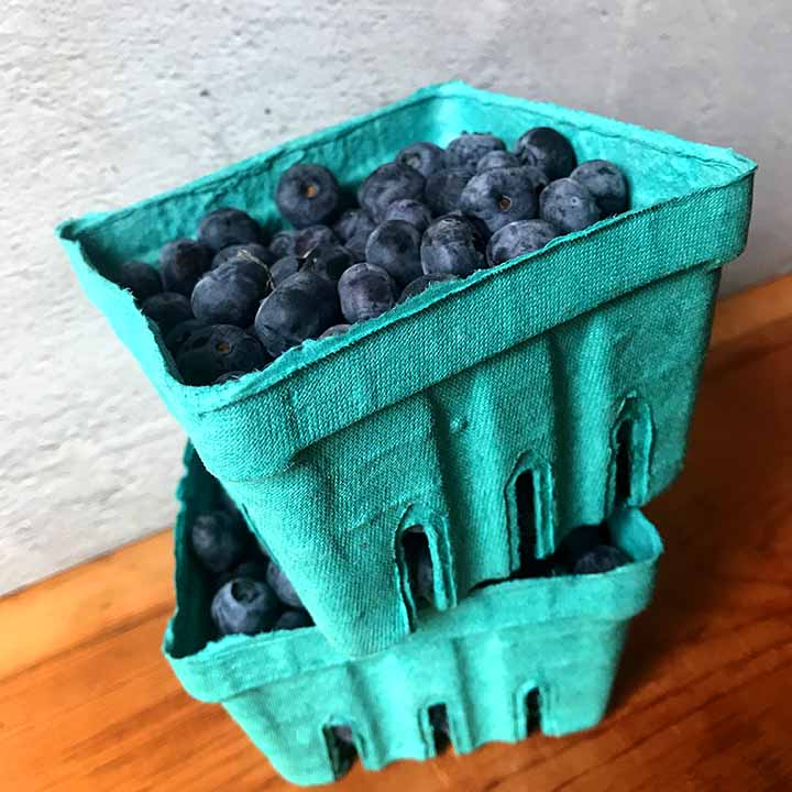 2 green containers filled with blueberries