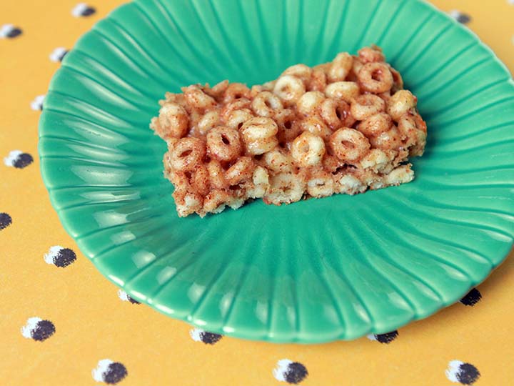 a low carb keto cereal bar on a green plate against a yellow patterned background