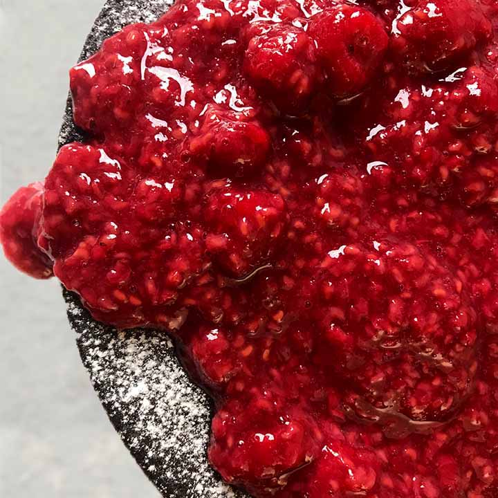 A top down shot of keto chocolate cake with raspberries
