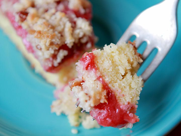 A forkful of low carb keto strawberry crumb cake against a blue plate
