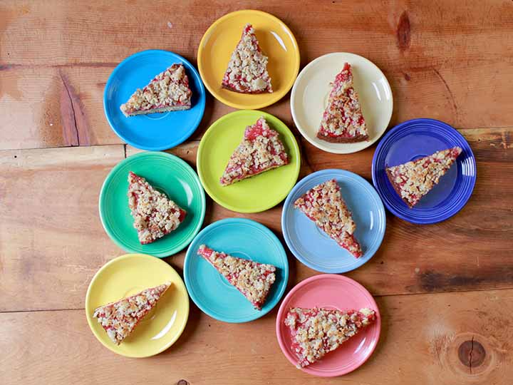 Top down shot of colorful plates holding slices of healthy strawberry streusel cake