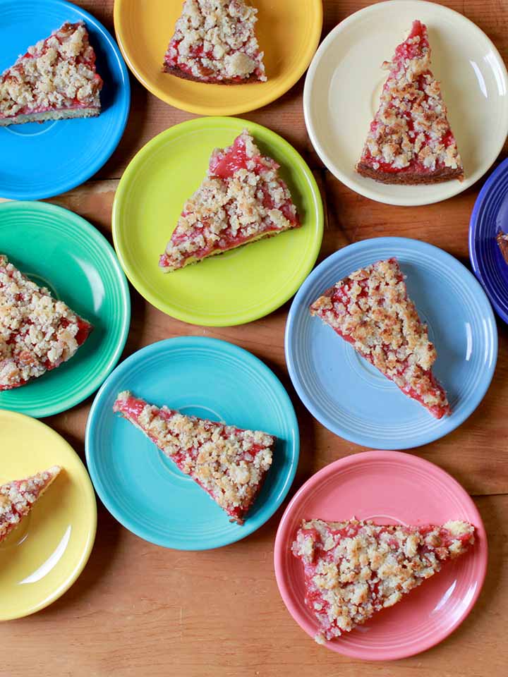 Top down shot of colorful plates holding slices of healthy strawberry streusel cake