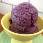 A yellow bowl holds 2 coops of Gluten Free Blueberry Ice Cream