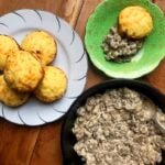 a plate of low carb Fathead biscuits, a pan of sausage gravy and a plate with a sausage gravy biscuit