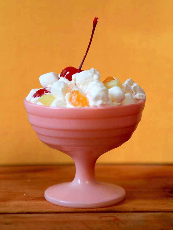 A pink sorbet bowl holding a scoop of Simple Ambrosia Salad