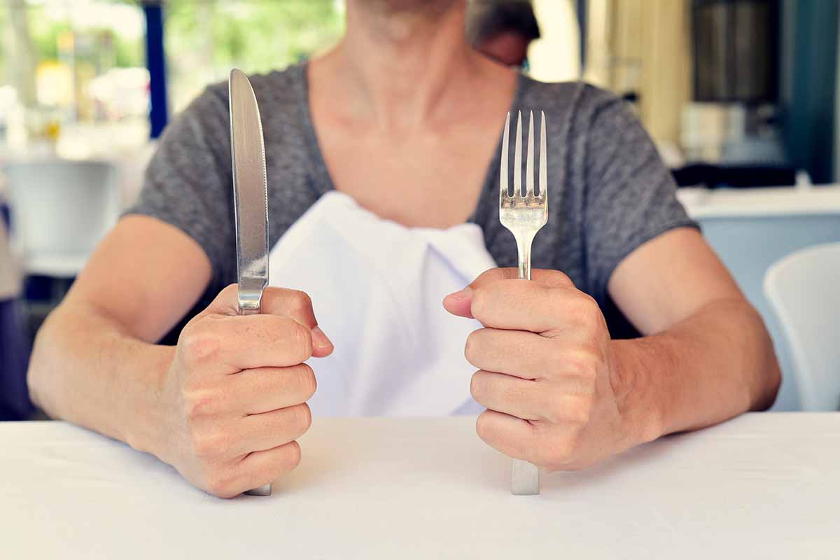 a woman sits in a restaurant waiting for food.