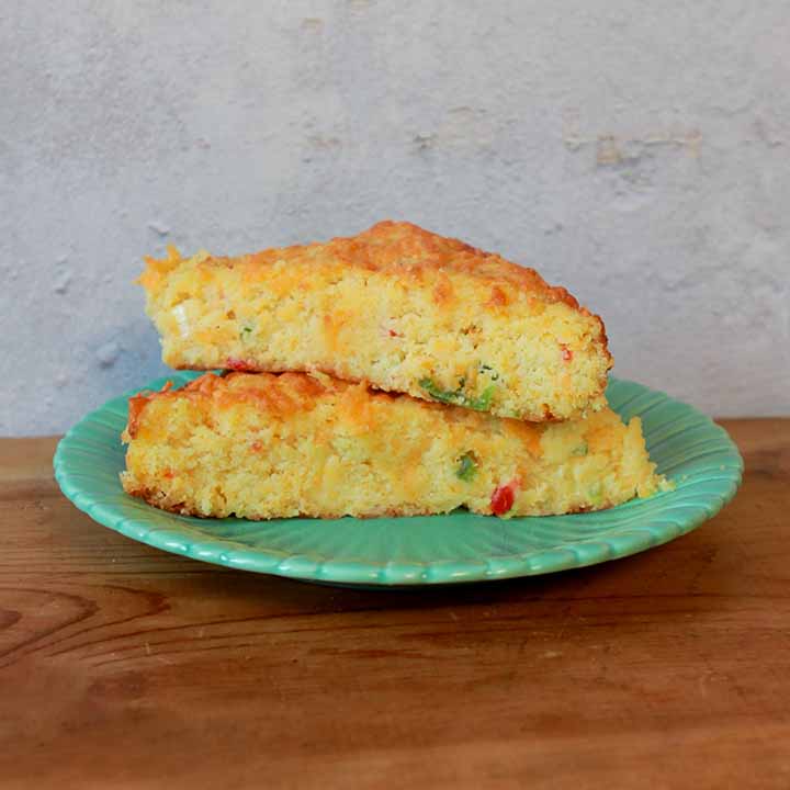 a stack of low carb Keto cheesy cornbread on a green plate on a wooden tabletop