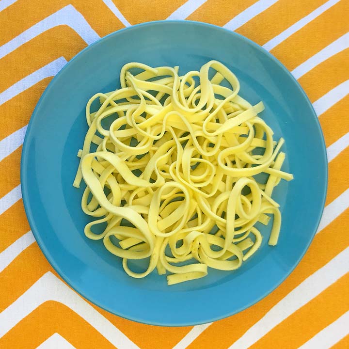 a blue plate holds fettuccine noodles