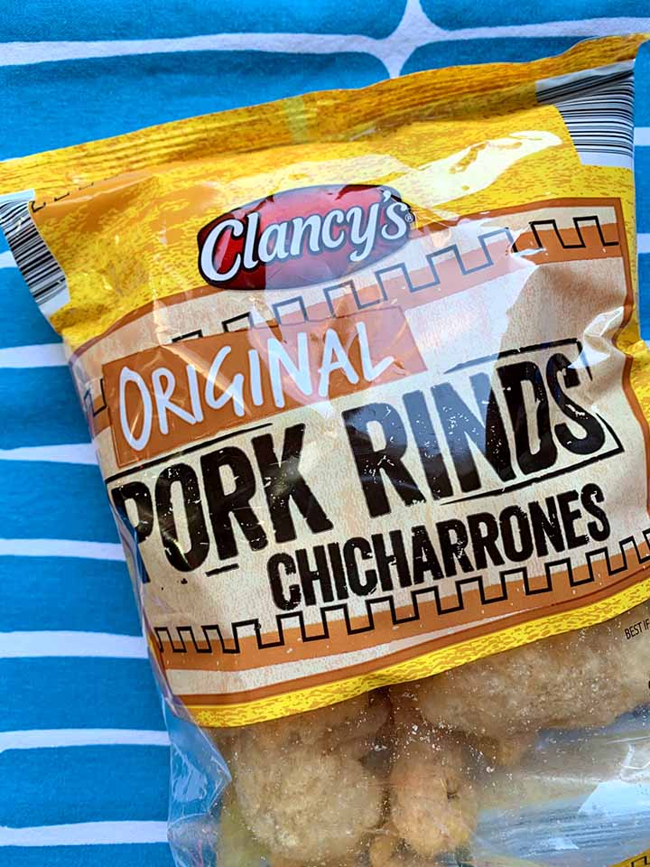 a bag of zero carb pork rinds against a blue patterned background
