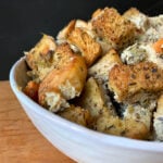 a side view of a white bowl holding Keto Thanksgiving Stuffing against a black background