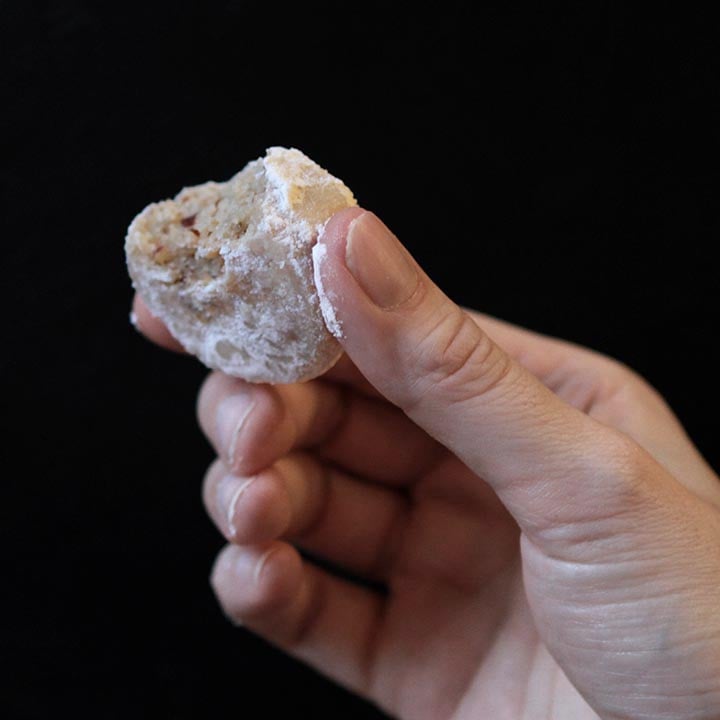 a hand holds a Keto Russian Tea Cake