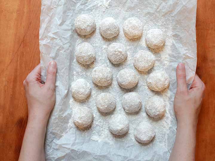 2 hands hold a tray of sugar-free Snowball Cookies