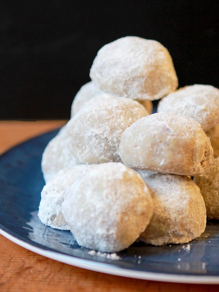 a stack of low carb Snowball Cookies against a black background