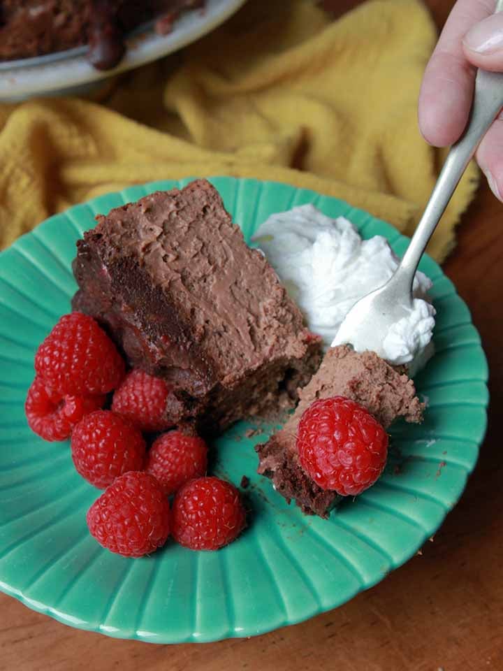 a hand takes a bite of healthy chocolate cheesecake