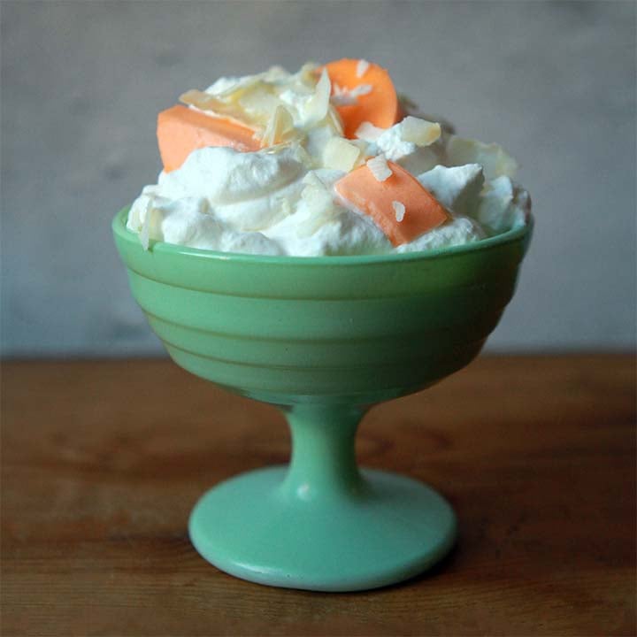 a bowl of whipped cream and orange Jello slices