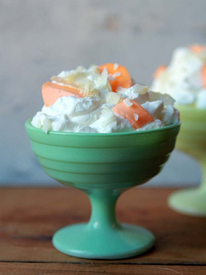 a bowl of whipped cream and orange Jello slices
